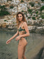 A girl wearing the Amarelle bikini, embracing the beach vibes and the vibrant patterns of her swimsuit while enjoying the refreshing ocean breeze