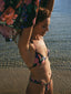 A girl wearing a triangle bikini, enjoying a sunny day on the beach